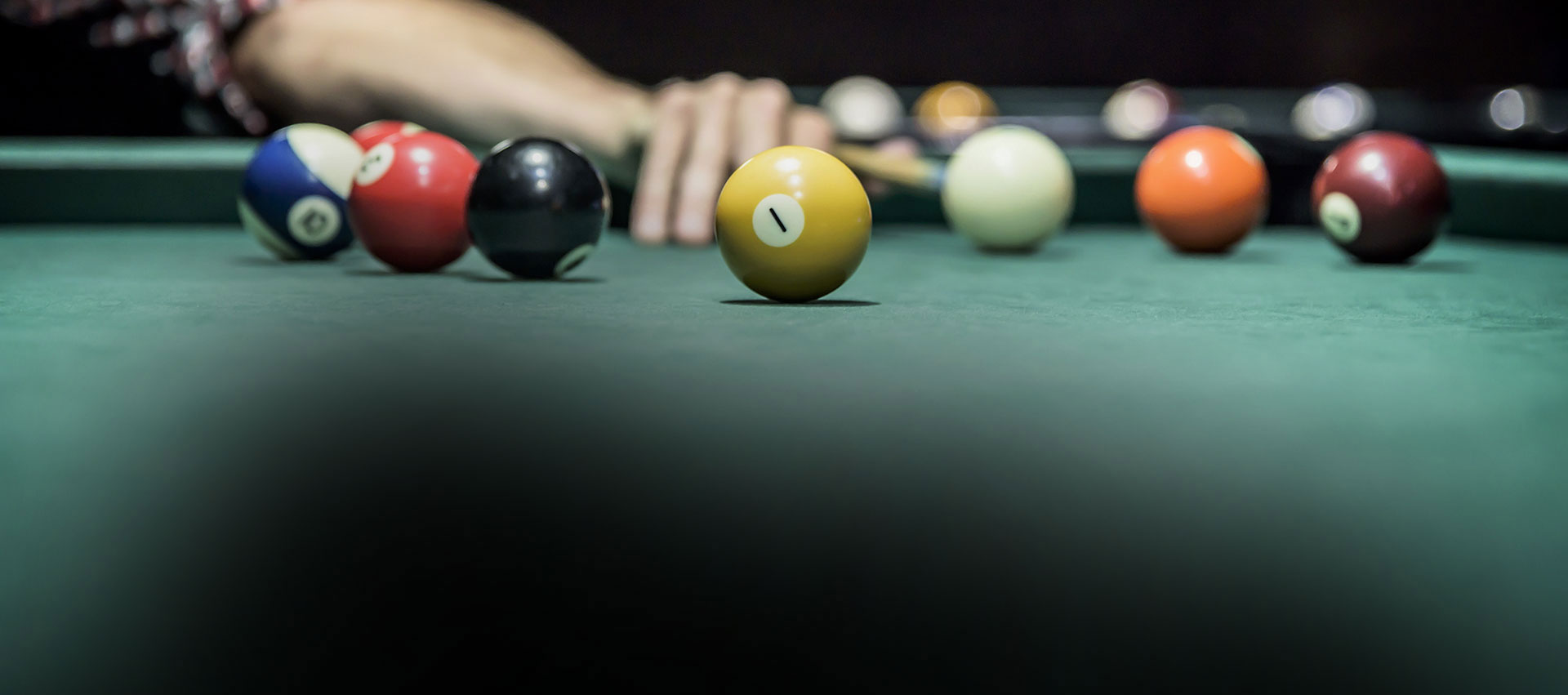 Ein Spieler zielt mit dem Queue auf die weiße Kugel